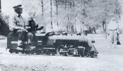 Buzz Sutch riding as passenger on his 1-1/2 inch scale Atlantic at the Los Angeles Live Steamers Golden Spike event, 5 May 1957.