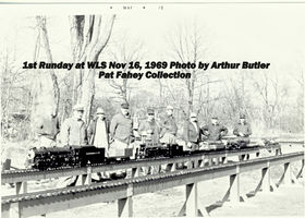 First Runday at the second new home of Waushakum Live Steamers at Norfolk St in Holliston, Mass. The lineup includes, left to right: Trowbridge Bent, George Hildreth, Percy Cone, Larry Blank, George Dimond, Tom Otis, Capt Child, Al Giffin, Bill VanBrocklin, Arthur Butler. Larry Blank gave George Hildreth the idea to build the small covered bridge at Norfolk St. track site. Photo by Arthur Butler, 16 November 1969. From the Pat Fahey Collection.