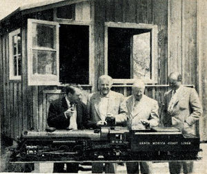 Bob Day's} home, left to right are Dave Rose, Les Friend, Dick Jackson and Bob Day. In the background is the Engine House. The locomotive is on the hydraulic hoist used to lift it from ground level to bench top in house. The hoist also serves as a turntable. From "The Miniature Locomotive", Nov-Dec 1952.