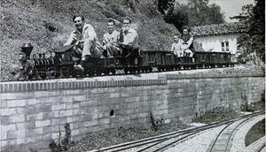 Walt Disney hauls passengers with his scale-model live steamer Lilly Belle over railroad on his estate