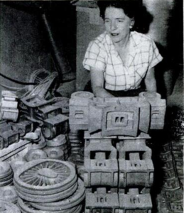 Locomotives in the rough: This stockpile of castings surrounding Mrs. Lewis is drawn on to make up kits for model railroaders the world over and to fill orders for individual parts.