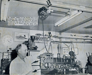 William Brower, member of the Golden Gate Live Steamers, Inc. shows how he hoists hi 3/4 inch scale Mastodon about his shop. In the background you can see the Governor Stanford which is in 1 inch scale and now under constructions. Photo by Woody Steen. From "The North American Live Steamer", Vol 1 No 5, 1956.